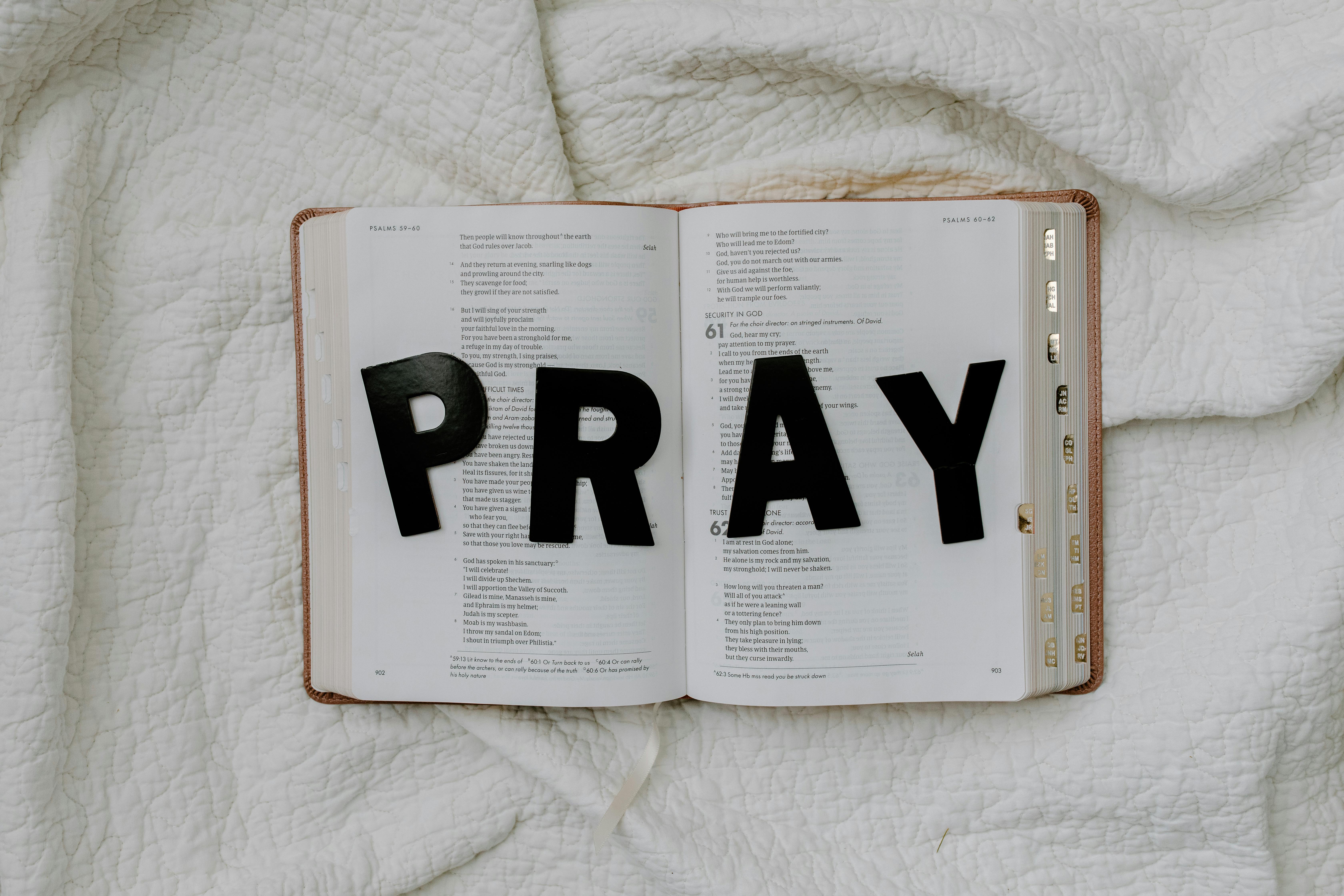 Buku terbuka dengan tulisan PRAY